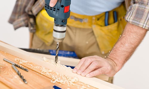 Careful hands-on furniture work with a drill